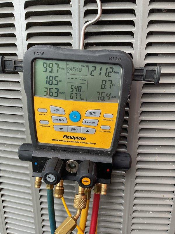 Completed routine Air Care Cooling maintenance inspection on HVAC system. System pressures and temperatures were measured and found to be within normal operating parameters, with low side reading 99.7 PSIG at 18.5°F and high side reading 211.2 PSIG at 87°F. Minor debris accumulation was observed around the base of the equipment requiring attention during future service visits.