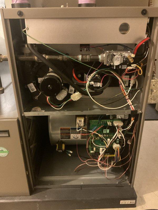Completed annual furnace maintenance on gas-fired heating system. Performed comprehensive tune-up including inspection of blower motor, gas valve assembly, ignition components, and all safety controls. Verified proper electrical connections throughout both upper and lower compartments, tested system operation with digital multimeter confirming appropriate voltage readings at 53.8V, and inspected all wiring harnesses and control boards. Unit operating within normal parameters with no deficiencies noted. All components functioning properly upon completion of scheduled maintenance.