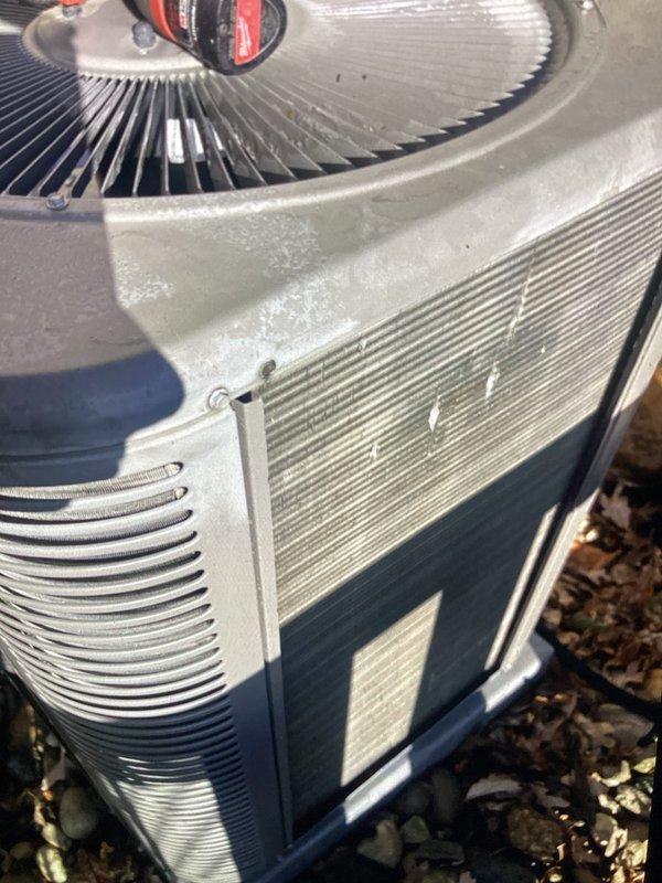 Completed Annual HVAC Checkup on residential air conditioning unit. Performed comprehensive system inspection including visual assessment of condenser unit exterior, fan assembly, and housing components. Unit found in operational condition with normal seasonal weathering present on exterior surfaces. Documented equipment condition through photographic records showing fan blades, ventilation slats, and overall unit integrity for maintenance history.