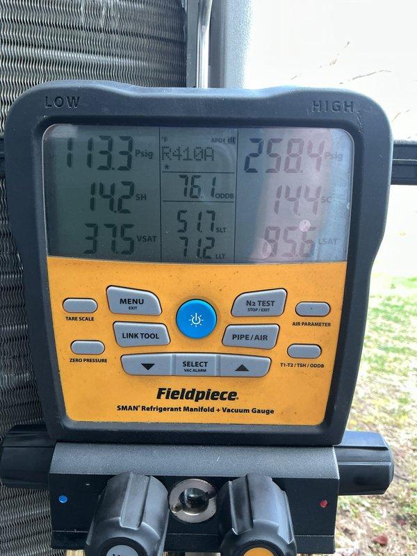 Completed routine AC clean and check on residential R410A system. Upon arrival, found outdoor condenser unit heavily clogged with dirt, debris, and organic material coating exterior surfaces and coil fins, with vines draped across unit face. Performed thorough cleaning of condenser coil and exterior housing to restore proper airflow. Checked system operating pressures and temperatures using refrigerant manifold gauge, recording 113.3 psig suction pressure and 258.4 psig discharge pressure with superheat at 142°F and subcooling at 144°F. System operating within acceptable parameters following cleaning. Unit restored to proper operating condition.