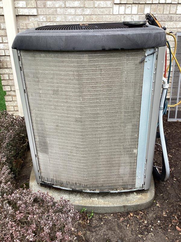 # HVAC Maintenance - ACM Completed

Performed routine air conditioning maintenance on residential outdoor condenser unit positioned against exterior brick wall. Conducted comprehensive system inspection including visual assessment of cabinet condition, refrigerant line connections, and electrical components. Unit showed signs of normal weathering with accumulation of dirt and debris on exterior fins and louvers. Verified concrete pad stability and proper unit positioning. Checked condenser coil condition and airflow through horizontal louvers. Inspected protective fan grille cover and confirmed secure mounting. Examined copper tubing connections and electrical line routing on right side of unit for any visible damage or wear. System operational and ready for continued cooling service.
