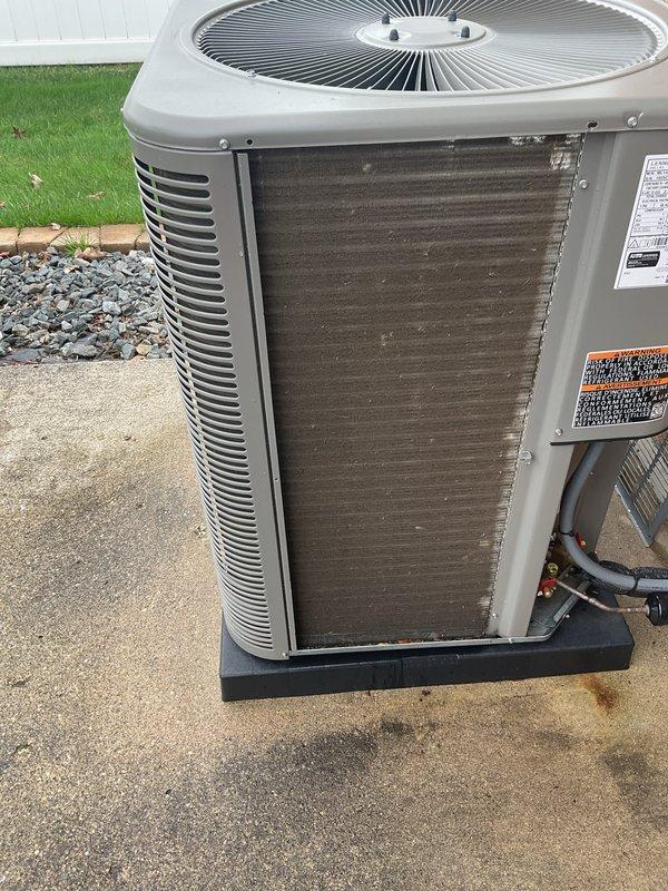 Completed scheduled Air Care Cooling maintenance on residential air conditioning system. Performed standard ACM inspection including electrical testing with clamp meter, which confirmed proper amperage draw at 0.95 amps. Inspected outdoor condenser unit, noting darkened and debris-laden condenser coils requiring attention, though unit remains operational with adequate airflow through top-mounted fan assembly and side louvers.