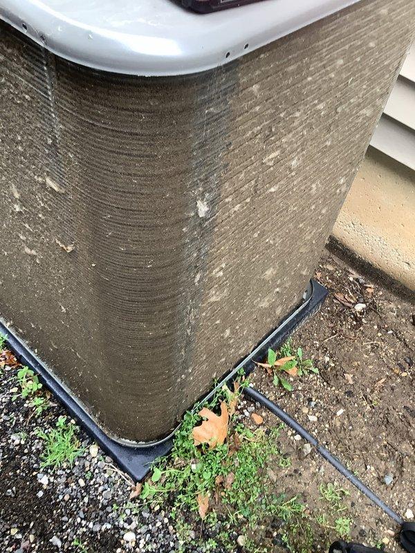 Completed annual cooling maintenance on residential air conditioning system. Performed comprehensive inspection of outdoor condenser unit, which showed significant accumulation of dirt, debris, and organic matter on exterior surfaces and surrounding installation area. Cleaned condenser coils, removed debris from unit base and adjacent spaces, verified refrigerant line connections, and confirmed proper drainage function. Unit operational and ready for cooling season.