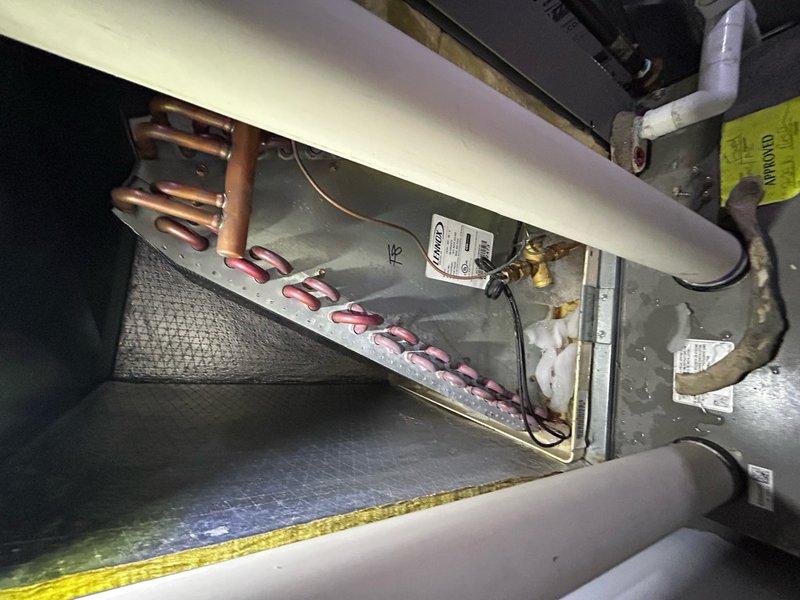 Responded to callback for 10-year-old Lennox air conditioning system experiencing water leakage into basement, failure to start, and previous evaporator coil icing. Upon inspection, verified outdoor condenser unit operational with proper refrigerant line connections and electrical supply intact. Examined basement-located indoor air handler and evaporator coil assembly, identifying condensate drainage issue as primary cause of water intrusion. Cleared blocked condensate drain line, verified proper drainage flow, and confirmed evaporator coil no longer freezing due to restored airflow and drainage. Checked refrigerant pressures, amperage draw, and thermostat operation to ensure system cycling correctly. System restored to normal cooling operation with no active leaks or icing present at time of service completion.