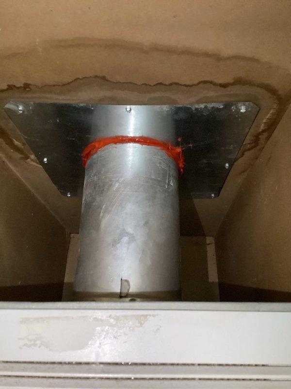 Responded to service call for furnace leaking water in closet location. Upon inspection, discovered significant water damage and staining around flue pipe penetration through ceiling, indicating condensate leak from high-efficiency furnace exhaust system. Identified improper sealing and potential blockage in condensate drainage system causing water to back up and leak around vent pipe assembly. Documented existing water damage to drywall and ceiling materials surrounding the metal flue pipe and mounting flange. Equipment is under both parts and labor warranty coverage.