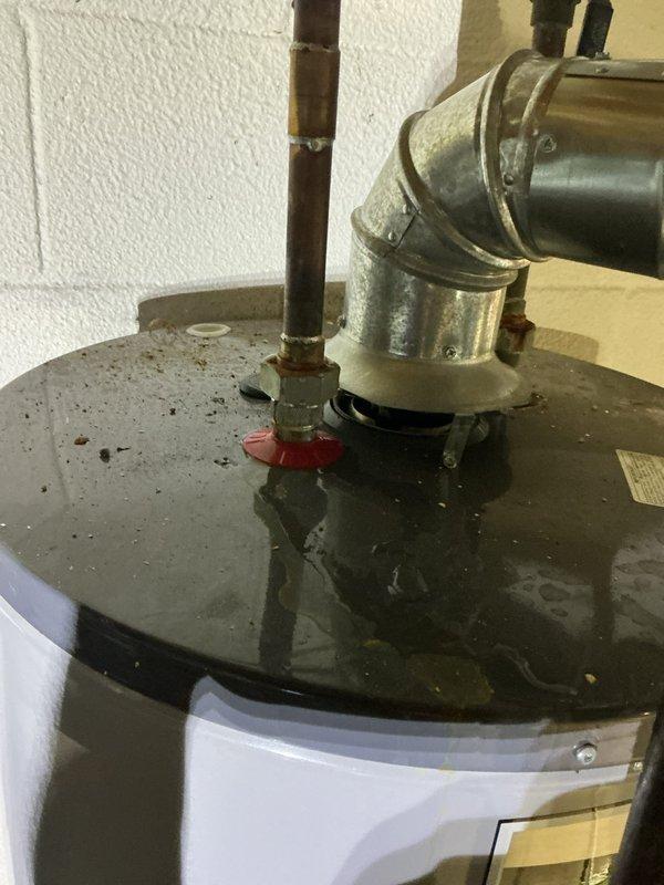 Performed diagnostic inspection on residential tanked water heater experiencing moisture accumulation at base of unit. Upon arrival, observed significant water pooling on concrete floor surrounding water heater, indicating active leak or condensation issue. Conducted thorough visual examination of tank exterior, plumbing connections, temperature and pressure relief valve, and drain valve assembly. Inspected copper supply lines and shutoff valves at top of unit for signs of corrosion or fitting failures. Evaluated control valve assembly and bottom drain connection for potential leak sources. Documented existing conditions with photographic evidence showing water damage patterns on floor and overall system configuration. Advised customer that no warranty coverage applies to this service call for parts or labor. Customer declined further repairs at this time following diagnostic assessment.