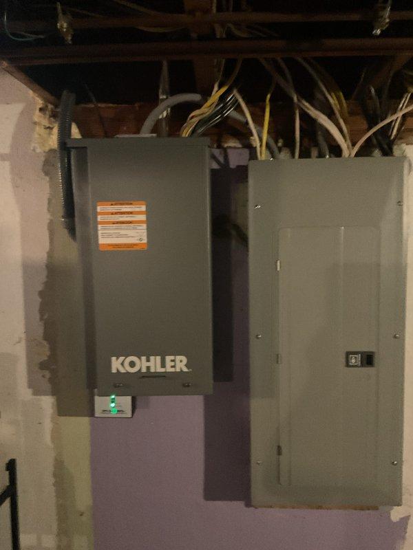 Completed full installation of Kohler residential standby generator system including exterior generator unit mounted on concrete pad, interior Kohler transfer switch panel, and essential circuits panel in basement utility area. Coordinated and obtained all required permits for mechanical, electrical, generator, gas piping, pressure testing, and transfer switch components. Successfully integrated generator system with existing electrical service, completed all necessary wiring connections through basement ceiling joists, and verified proper operation of transfer switch with indicator lights functioning correctly.