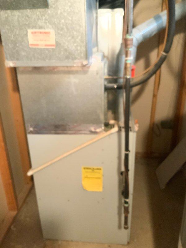 Provided comprehensive estimate for complete HVAC system replacement including both air conditioning condenser and natural gas furnace. Existing 26-27 year old equipment remains operational but has reached end of service life. Assessed basement installation with confined space considerations for furnace replacement and evaluated outdoor condenser unit positioned on concrete pad against exterior brick wall with existing refrigerant line routing and electrical disconnect configuration.