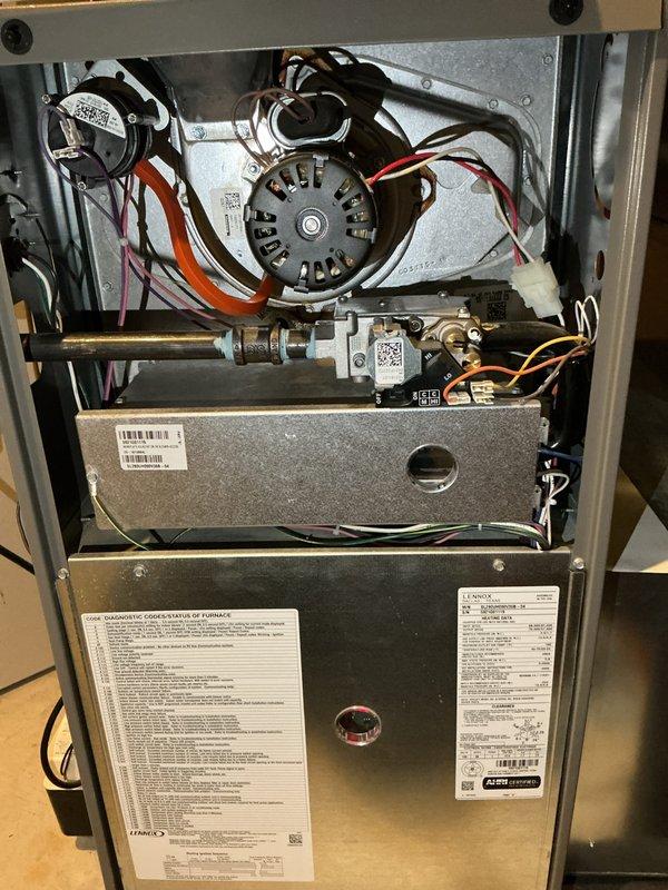 Completed annual furnace maintenance and tune-up on residential heating system. Performed comprehensive inspection of blower motor assembly, capacitor, gas valve connections, and main control board. Verified all electrical connections, wire harnesses, and safety controls are functioning properly. Documented equipment condition with interior cabinet photos showing motor assembly, combustion chamber, and control components in good operational status.