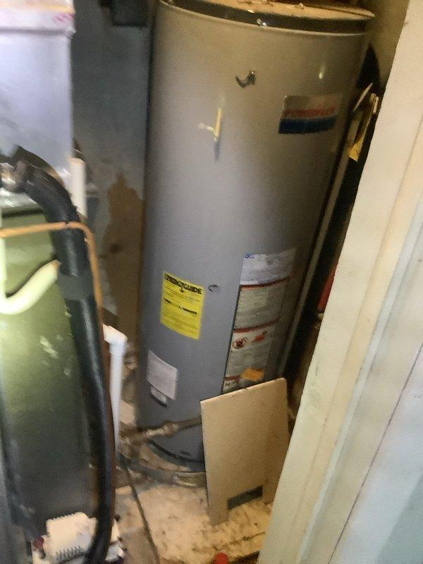 Responded to service call for air conditioning unit producing loud noise during operation and hot water heater failing to heat properly. Both units located in interior closet. Air conditioning system is less than one month old and covered under parts and labor warranty. Performed diagnostic inspection of AC unit to identify source of operational noise. Conducted assessment of hot water heater to determine cause of heating failure. Documented equipment condition and installation configuration with photographic evidence showing water heater with standard plumbing connections, color-coded supply lines, flue pipe, and manufacturer labeling intact.