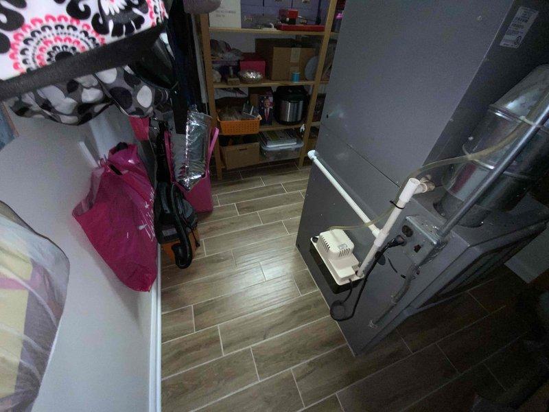 Provided estimate for furnace and air conditioning replacement system under BOGO promotion for 23-year-old equipment currently located in basement utility area. Existing HVAC system is operational but at end of service life, with air handler positioned in confined space with limited clearance beneath low ceiling. Equipment replacement quote prepared to address aging infrastructure and improve system efficiency.