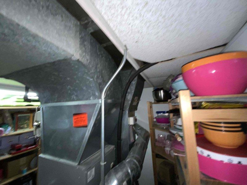 Provided estimate for furnace and air conditioning replacement system under BOGO promotion for 23-year-old equipment currently located in basement utility area. Existing HVAC system is operational but at end of service life, with air handler positioned in confined space with limited clearance beneath low ceiling. Equipment replacement quote prepared to address aging infrastructure and improve system efficiency.