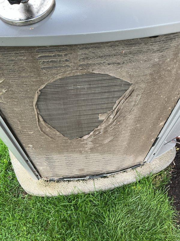 Completed annual cooling maintenance on residential HVAC system. Upon inspection, found condenser coil heavily soiled with accumulated dirt and debris, restricting airflow and reducing system efficiency. Unit exterior panel showed significant deterioration with damaged covering exposing underlying coil fins. Identified air filter requiring immediate replacement due to excessive contamination. Documented equipment condition with photographs showing weathered components and dirty coil surfaces. Recommended filter replacement as collect-on-delivery item to restore proper system operation and indoor air quality.