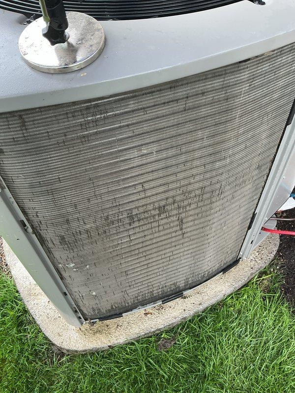 Completed annual cooling maintenance on residential HVAC system. Upon inspection, found condenser coil heavily soiled with accumulated dirt and debris, restricting airflow and reducing system efficiency. Unit exterior panel showed significant deterioration with damaged covering exposing underlying coil fins. Identified air filter requiring immediate replacement due to excessive contamination. Documented equipment condition with photographs showing weathered components and dirty coil surfaces. Recommended filter replacement as collect-on-delivery item to restore proper system operation and indoor air quality.