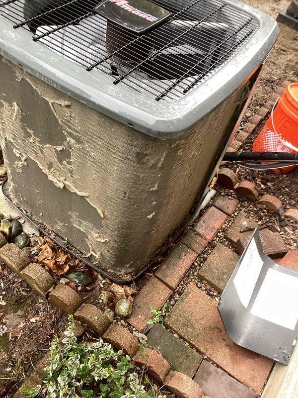 Completed annual cooling maintenance on residential outdoor condenser unit. Performed comprehensive system inspection, photographed equipment condition noting significant exterior paint deterioration and cabinet wear. Documented debris accumulation around unit base including leaves, dirt, and vegetation growth between paver joints. Verified electrical disconnect accessibility and proper safety cone placement during service. Unit operational upon completion of maintenance protocol.