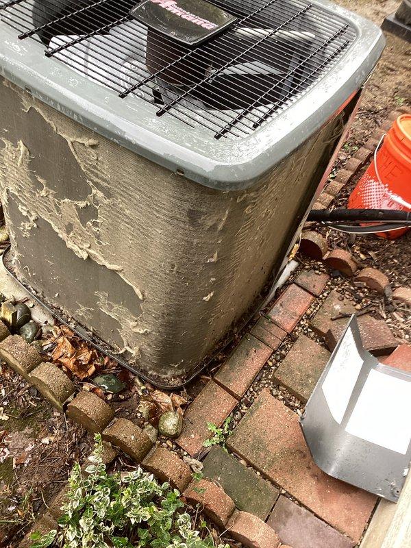 Completed annual cooling maintenance on residential outdoor condenser unit. Performed comprehensive system inspection, photographed equipment condition noting significant exterior paint deterioration and cabinet wear. Documented debris accumulation around unit base including leaves, dirt, and vegetation growth between paver joints. Verified electrical disconnect accessibility and proper safety cone placement during service. Unit operational upon completion of maintenance protocol.