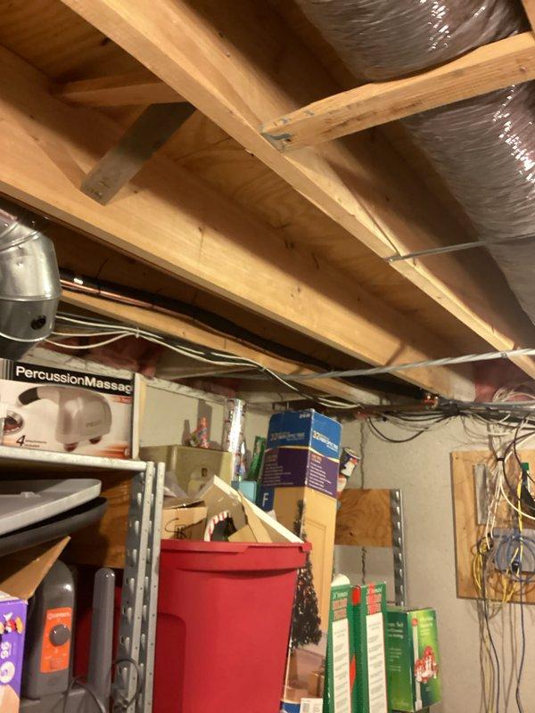 Completed installation of 3.5-ton air conditioning system with matching evaporator coil in residential basement location. Unit positioned on right-side configuration with copper refrigerant lines professionally routed and secured, connected to existing furnace system with proper ductwork integration. All mechanical and electrical permits obtained, condensate drainage system installed with PVC piping, and system reconnected and tested for proper operation.