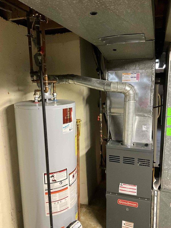 Provided estimate for replacement of 20-year-old Goodman furnace located in basement utility area. Current unit is operational but has reached end of expected service life. Assessed existing installation including ductwork connections, gas line configuration, electrical service, and clearances in mechanical room shared with water heater.