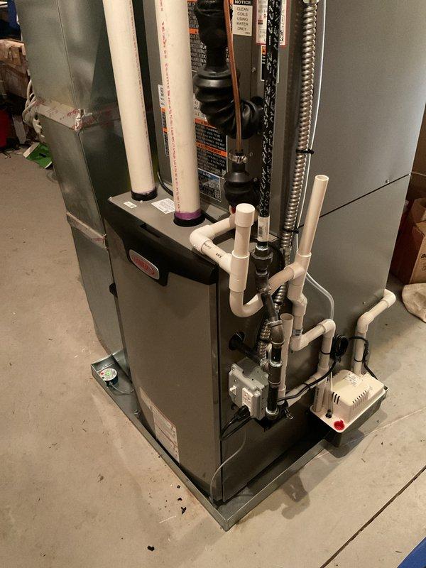 Completed full HVAC system installation including a 70,000 BTU furnace with rear discharge configuration, 2-ton air conditioning unit, and humidifier in basement utility area. Installed all necessary PVC venting and condensate drainage systems, reconnected gas lines with proper support chains, and integrated metallic ductwork to existing infrastructure. All permits were obtained, system tested and operational upon completion.