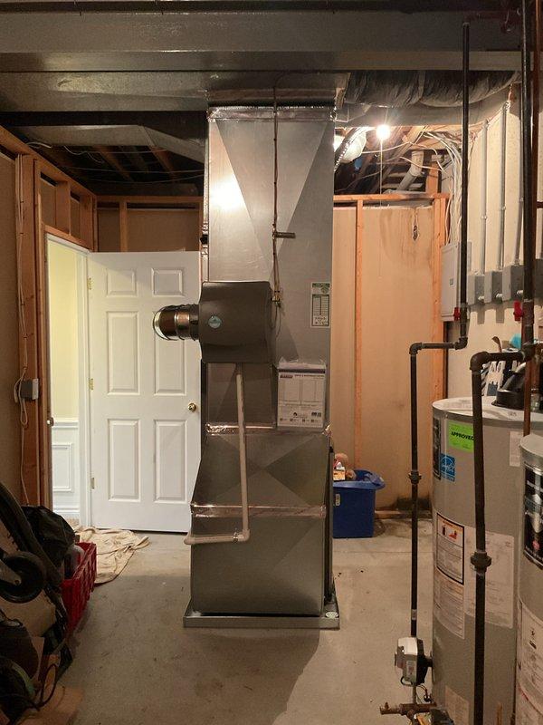 Completed full HVAC system installation including a 70,000 BTU furnace with rear discharge configuration, 2-ton air conditioning unit, and humidifier in basement utility area. Installed all necessary PVC venting and condensate drainage systems, reconnected gas lines with proper support chains, and integrated metallic ductwork to existing infrastructure. All permits were obtained, system tested and operational upon completion.