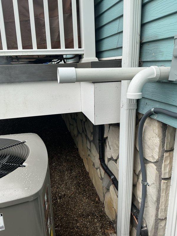 Completed full HVAC system installation including a 90,000 BTU gas furnace and 3-ton air conditioning unit with rear discharge configuration. Installed condensate drainage system with white PVC piping routed along exterior foundation wall, mounted outdoor condenser unit on gravel pad adjacent to building foundation, and completed all refrigerant line connections. Added whole-home humidifier unit to furnace ductwork in basement mechanical room with proper water supply and drainage connections, secured all copper refrigerant lines to ceiling joists, and reconnected all electrical components to existing service. Mechanical and electrical permits were obtained prior to installation, and all work was completed per code requirements with system tested and operational upon completion.