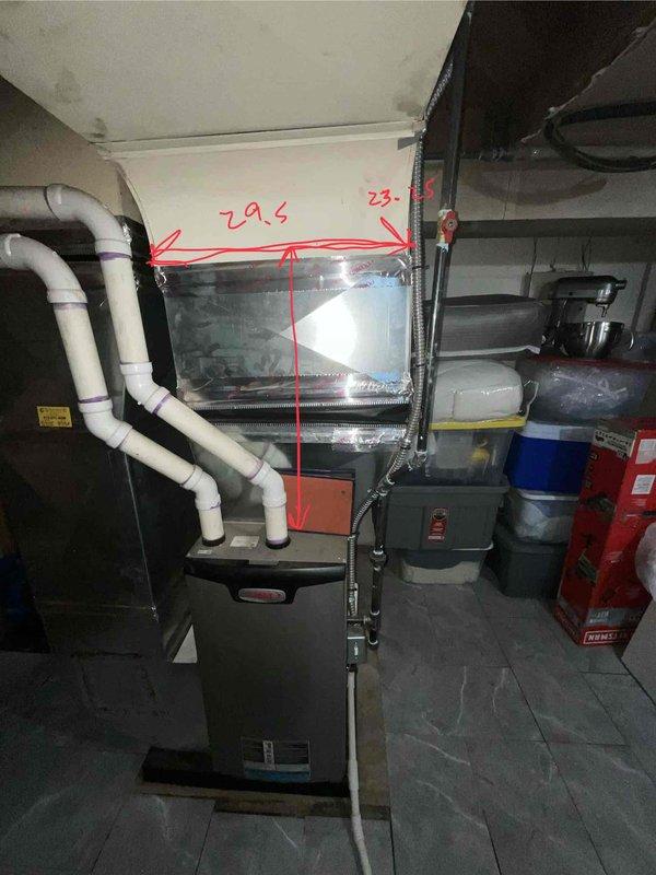 Conducted comprehensive assessment of non-functional residential air conditioning system in basement utility area alongside existing 5-year-old natural gas furnace. Documented current HVAC configuration including furnace unit with diamond-pattern casing, existing PVC condensate drainage network, and measured clearance dimensions of 20.5 inches and 23 inches for equipment replacement planning. Evaluated installation space constraints with adjacent water heater and water treatment equipment to determine optimal positioning for new air conditioning system compatible with existing natural gas heating infrastructure.