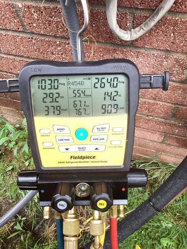Responded to service call for gurgling sound from 3-month-old outdoor A/C unit. Upon arrival, connected refrigerant manifold and vacuum gauge to system and performed diagnostic pressure and temperature readings on R454B refrigerant system. Measurements indicated pressures of 1030 psig on low side and 2642 psig on high side with corresponding temperatures of 292°F and 142°F. Inspected exterior refrigerant line set running along building exterior and mounting points. Determined gurgling noise was caused by refrigerant flow characteristics within the line set, which is normal operation for this newer refrigerant type in recently installed equipment. System operating within manufacturer specifications. No repairs required. Unit covered under parts and labor warranty. Customer advised that sound is normal for R454B systems and does not indicate malfunction.