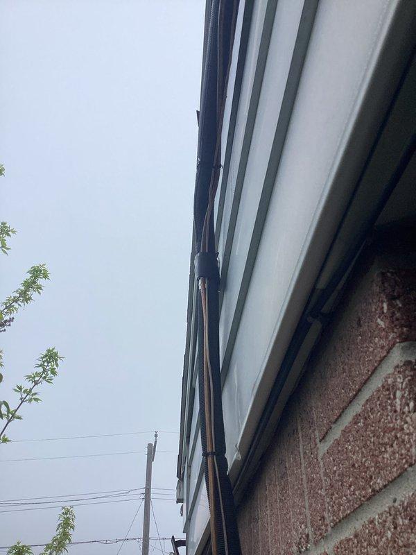 Responded to service call for gurgling sound from 3-month-old outdoor A/C unit. Upon arrival, connected refrigerant manifold and vacuum gauge to system and performed diagnostic pressure and temperature readings on R454B refrigerant system. Measurements indicated pressures of 1030 psig on low side and 2642 psig on high side with corresponding temperatures of 292°F and 142°F. Inspected exterior refrigerant line set running along building exterior and mounting points. Determined gurgling noise was caused by refrigerant flow characteristics within the line set, which is normal operation for this newer refrigerant type in recently installed equipment. System operating within manufacturer specifications. No repairs required. Unit covered under parts and labor warranty. Customer advised that sound is normal for R454B systems and does not indicate malfunction.