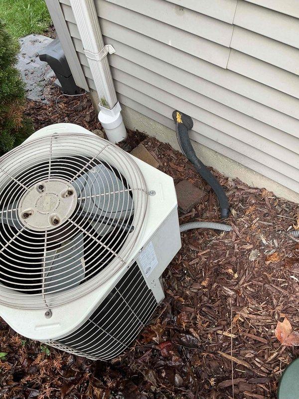 Conducted comprehensive assessment of existing 16-year-old air conditioning system that ceased operation during previous cooling season. Evaluated both indoor air handler unit located in basement mechanical room and outdoor condensing unit positioned against exterior wall with mulch bedding. Inspected electrical connections, condensate drainage system with PVC piping, and overall equipment condition. Documented current installation configuration including existing furnace that was replaced 13 years prior, while original AC system remained in service until failure. Provided full system replacement estimate for new HVAC equipment to address failed air conditioning unit and ensure proper system matching with existing infrastructure. Photographed existing equipment placement, electrical conduit routing, drainage lines, and installation environment for replacement planning purposes.