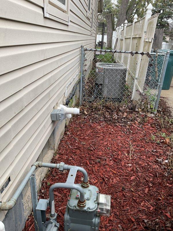 Responded to recall for GFCI compliance on recent HVAC installation. Inspected outdoor condensing unit location and confirmed electrical outlet installation meets NEC requirements for ground fault circuit interrupter protection within 25 feet of exterior equipment. Verified proper GFCI functionality and documented installation with photographs showing unit placement, electrical connections, and surrounding utility infrastructure including gas meter and foundation drainage systems.