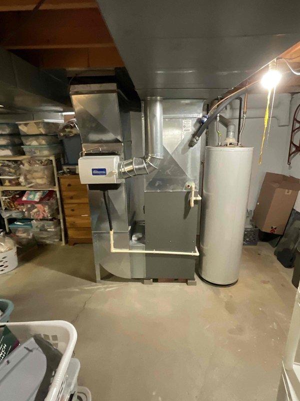 Conducted comprehensive assessment of 20-year-old residential HVAC system for replacement estimate, including natural gas furnace located in basement utility area and Bryant air conditioning condenser unit positioned in exterior side yard. Furnace currently operational while air conditioning unit non-functional. Documented existing equipment configuration, ductwork connections, electrical systems, clearances, and installation access points for complete system replacement proposal.