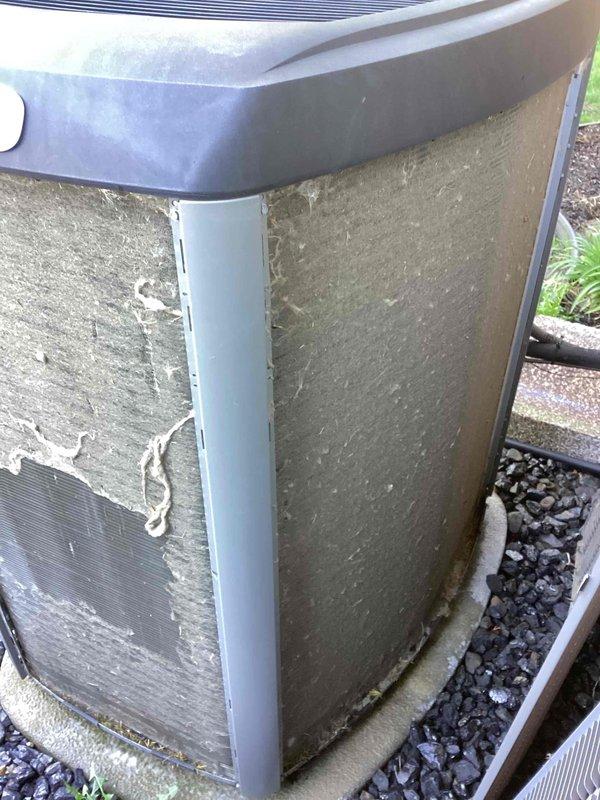 Completed annual cooling maintenance on residential air conditioning condenser unit. Performed system inspection, replaced air filter and evaporator pad as part of scheduled preventative maintenance program. Unit exterior shows significant weathering and coating deterioration on panels, though system remains operational. Documentation photos captured for service records and future reference regarding cabinet condition.
