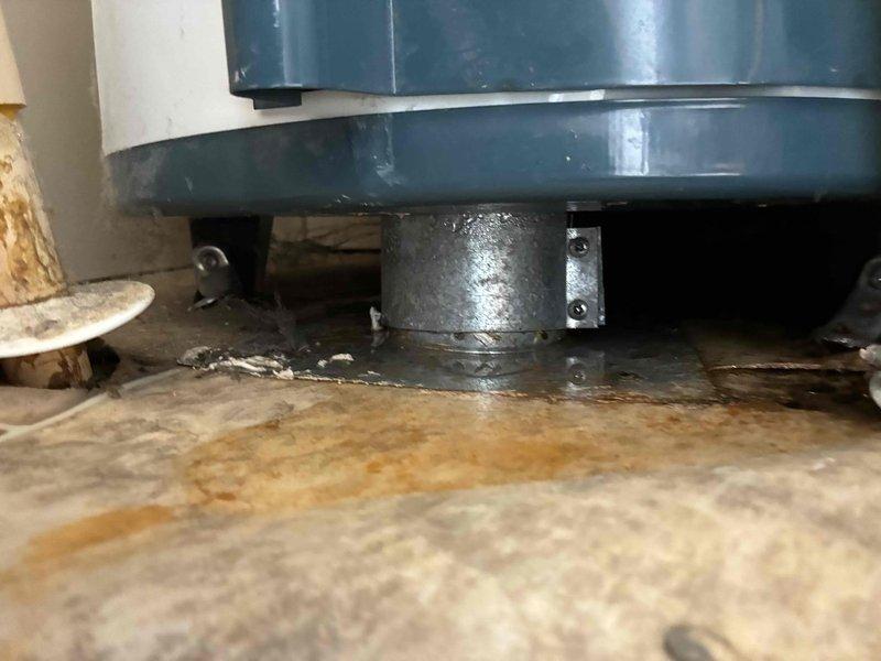 Responded to service call for non-operational water heater located in closet of mobile home. Conducted thorough assessment of existing unit and surrounding installation conditions. Documented equipment condition, including water heater base, floor mounting configuration, and utility space constraints typical of mobile home installations. Observed significant floor staining and debris accumulation around unit base, indicating potential previous leakage or drainage issues. Photographed mechanical connections, mounting hardware, and surrounding structural elements including insulation and support components to provide comprehensive estimate documentation for water heater replacement.