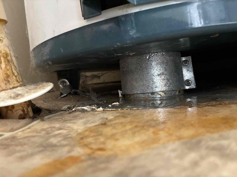 Responded to service call for non-operational water heater located in closet of mobile home. Conducted thorough assessment of existing unit and surrounding installation conditions. Documented equipment condition, including water heater base, floor mounting configuration, and utility space constraints typical of mobile home installations. Observed significant floor staining and debris accumulation around unit base, indicating potential previous leakage or drainage issues. Photographed mechanical connections, mounting hardware, and surrounding structural elements including insulation and support components to provide comprehensive estimate documentation for water heater replacement.