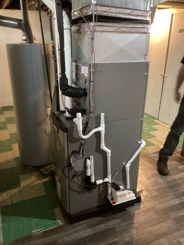 Completed full HVAC system installation including a 70,000 BTU furnace and 2-ton air conditioning unit with rear discharge configuration in residential basement. Installed all necessary ductwork connections, PVC venting and drainage piping, condensate pump, gas line reconnection, and electrical connections per mechanical and electrical permits. System tested and operational upon completion.