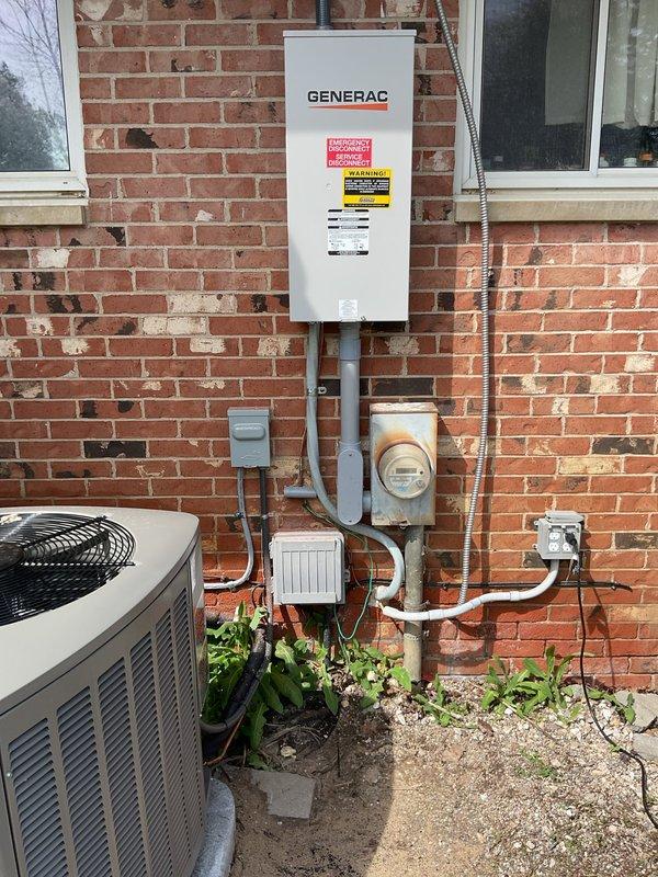 Responded to callback for generator installation follow-up. Returned generator keys to property owner and inspected Generac transfer switch panel mounted on exterior brick wall. Evaluated empty electrical box installation and provided homeowner with recommendations for removal options to improve aesthetic appearance and eliminate unnecessary equipment from exterior wall. Documented current electrical configuration including transfer switch, meter housing, and associated conduit routing with photographs for service records.