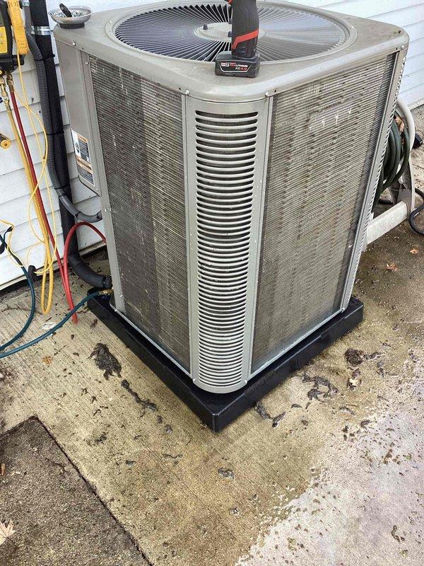 Responded to no cooling complaint on residential Trane system less than 2 years old. Upon arrival, found both furnace and AC unresponsive despite thermostat clicking when adjusted. Inspected outdoor condenser unit and documented condition showing significant dirt accumulation on coils and louvers, which can restrict airflow and reduce system efficiency. Photographed equipment for service records. System requires further diagnostic testing to determine root cause of complete system failure, as homeowner had already verified flood detector switch was not tripped.