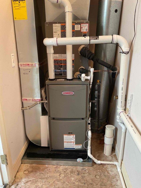 Completed dual-zone HVAC system installation consisting of two complete furnace and air conditioning combinations. Installed first system with 70,000 BTU Lennox furnace and 2.5-ton AC condenser unit positioned on right side of property, and second system with 90,000 BTU Lennox furnace and 3.5-ton AC condenser unit, also right-side mounted. Interior installation included proper venting configuration with white PVC piping for exhaust and intake, black flexible condensate drainage lines, and complete electrical connections with dedicated circuits and disconnect switches. Exterior condenser units mounted on concrete pads with gravel base for drainage, refrigerant line sets installed with proper insulation, and electrical disconnects mounted to building exterior. All mechanical, electrical, and plumbing permits obtained and work performed to code. Systems tested, operational, and ready for service.