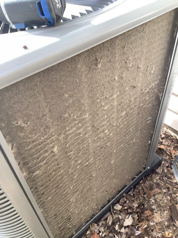 Completed scheduled ACM preventive maintenance on residential air conditioning system. Performed system diagnostics and recorded supply air temperature of 45.7°F using calibrated digital thermometer. Inspected outdoor condensing unit and identified heavily soiled air filter with significant accumulation of dirt, debris, and organic matter restricting airflow. Documented filter condition showing grayish-brown discoloration and streaked contamination patterns across surface. Unit operational with leaves and yard debris present around base requiring attention for proper system performance.