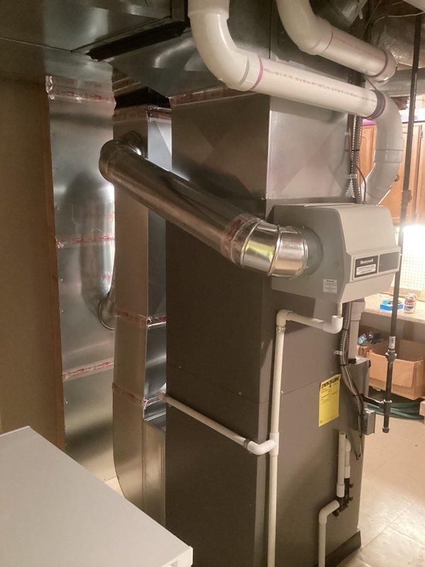 Completed full HVAC system installation including a 90,000 BTU gas furnace and 3.5-ton air conditioning unit with rear discharge configuration. Installed all required ductwork, PVC venting, humidifier integration, and electrical connections in basement utility area. System was evacuated to proper vacuum levels (335 microns verified), refrigerant lines connected, and all mechanical and electrical permits obtained for code compliance.