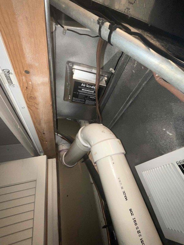 Conducted on-site estimate for air conditioning system replacement on 16-year-old unit. Documented existing equipment specifications from manufacturer label and photographed current installation including attic-mounted air handler with Air Scrubber air quality system and PVC condensate drainage. Customer requested immediate replacement timeline; follow-up quote to be provided for complete system replacement.