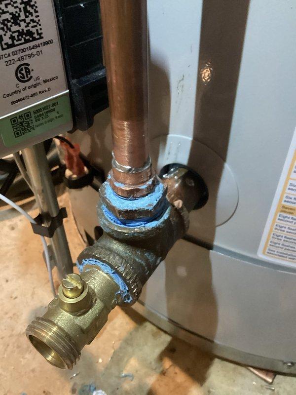 Responded to a water heater recirculation system leak at a threaded copper-to-brass fitting on the tie-in line. Drained the water heater tank completely, removed the defective soldered joint at the elbow connection, and re-soldered the fitting to establish a watertight seal. Service completed under full warranty coverage with no charge to the customer.