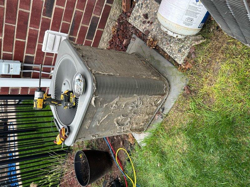 Responded to no-cool call on 15-year-old central air conditioning system. Upon arrival, confirmed outdoor condenser unit was not operating and thermostat was clicking but system failed to produce cold air. Customer also reported water leaking from furnace unit. Performed diagnostic evaluation of outdoor condenser unit, which showed heavy accumulation of dirt, grime, and debris on exterior surfaces and condenser coils, indicating extended period without maintenance. Connected HVAC diagnostic gauges to measure system pressures and temperatures. Readings indicated abnormal refrigerant pressures consistent with system failure. Inspected condenser fan motor and compressor for operation. Evaluated electrical connections and capacitor condition. Assessed condensate drainage from indoor evaporator coil, which was likely source of water leakage at furnace unit due to clogged drain line or frozen evaporator coil from lack of airflow. Given age of equipment at 15 years and extent of deferred main