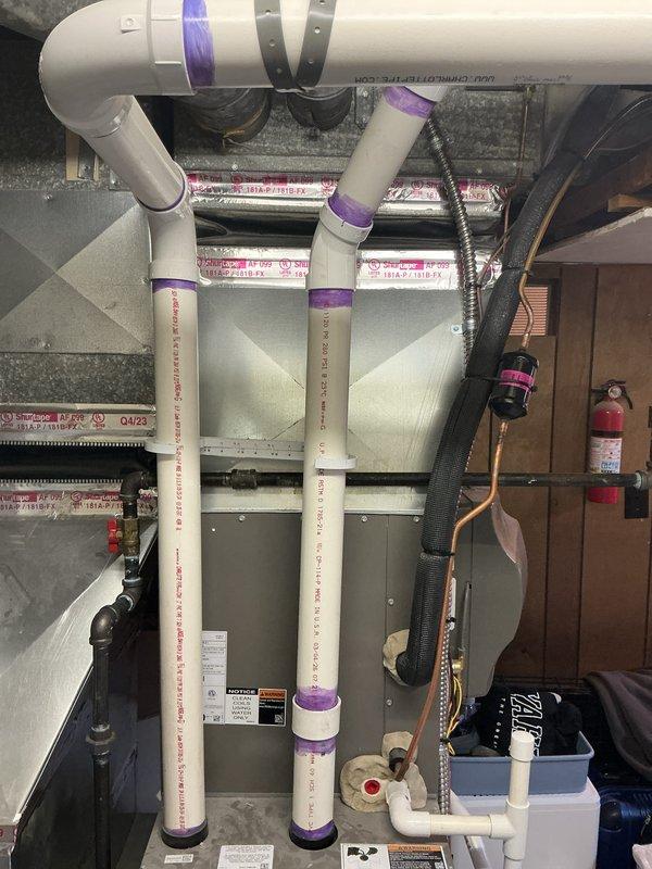 Completed callback inspection on recently installed 70,000 BTU furnace and 2-ton air conditioning system. Verified proper installation of PVC venting system with purple primer markings throughout vertical and horizontal runs, confirmed secure mounting of all ductwork and mechanical components in utility space. Noted potential combustion air deficiency requiring follow-up assessment to ensure adequate ventilation for safe furnace operation per code requirements.