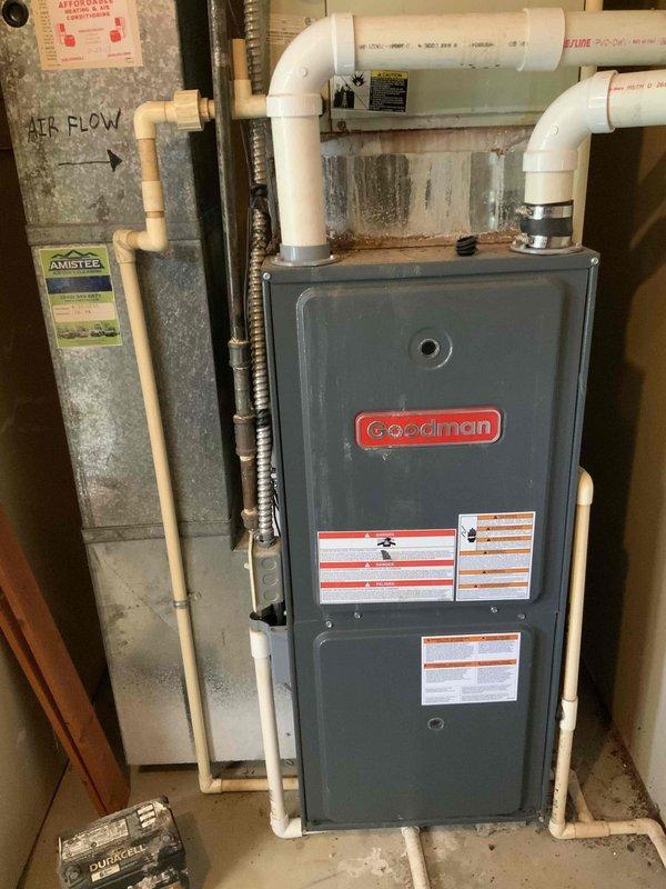 Completed full HVAC system installation in residential basement utility room, including new furnace unit with associated PVC venting and condensate drainage piping, air filter housing with proper airflow configuration, and necessary electrical connections. System was installed against existing masonry wall with all required safety labels and manufacturer specifications properly displayed, ensuring code-compliant operation and efficient heating performance.