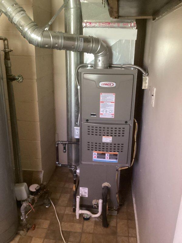 Completed installation of Lennox 70,000 BTU gas furnace in residential utility room. Performed mechanical and electrical connections, installed metal supply ductwork with proper transitions and elbows, ran copper refrigerant lines with secure mounting brackets, and connected white PVC condensate drain lines. Reconnected all existing duct connections and verified proper clearances around unit. All equipment tested and operational upon completion.