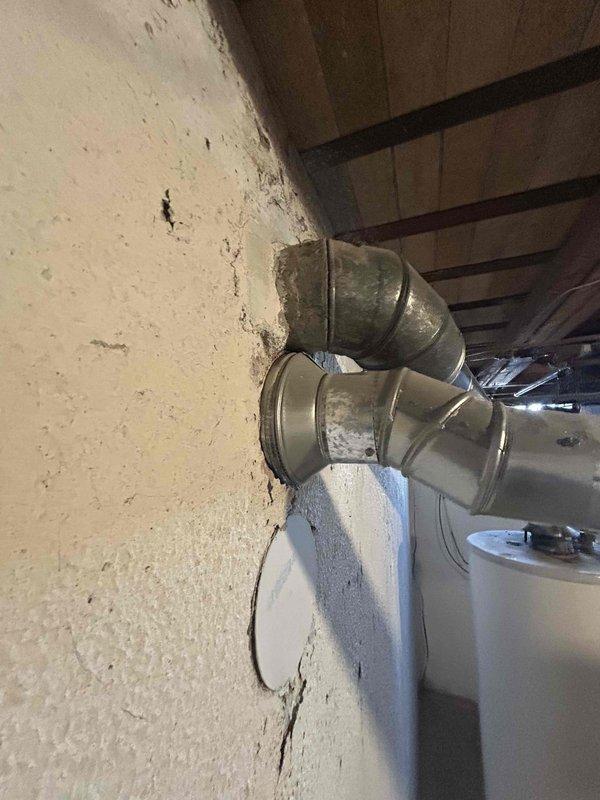 Completed site visit to assess 16-year-old HVAC system for full replacement estimate. Inspected existing ductwork in basement area, noting corrugated metal supply ducts with dust accumulation and aged elbow connections showing deterioration at wall penetration points. Documented current system configuration with photos of ductwork components and connections to facilitate accurate replacement proposal for customer requesting immediate system replacement.