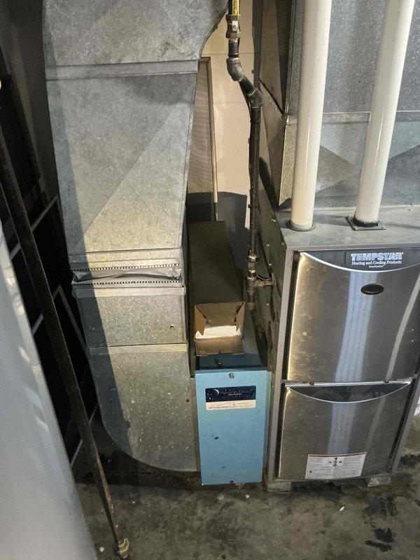 Completed replacement estimate for 30-year-old heating and cooling system in medium-sized residential property. Assessed existing basement-installed furnace and air conditioning unit, both natural gas/propane-fueled equipment serving 1200-2000 square feet. Documented current system configuration including exterior PVC ventilation components and interior HVAC equipment layout for replacement proposal.