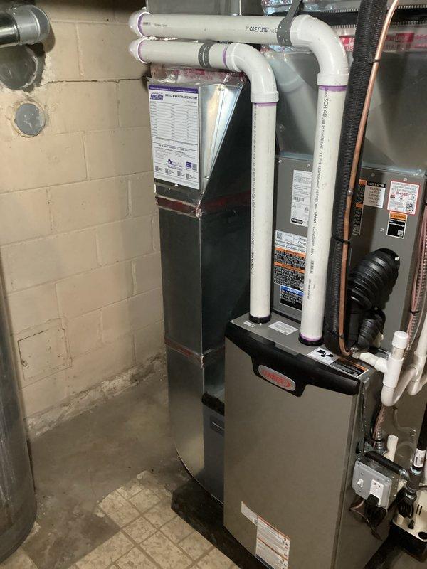 Completed full HVAC system installation including 70,000 BTU furnace with humidifier and liner, 2-ton air conditioning unit with rear discharge configuration, and new dedicated electrical circuit. All mechanical and electrical permits obtained prior to installation. System professionally installed in basement utility area with proper venting, PVC condensate drainage, copper refrigerant lines, and galvanized ductwork connections per code requirements.