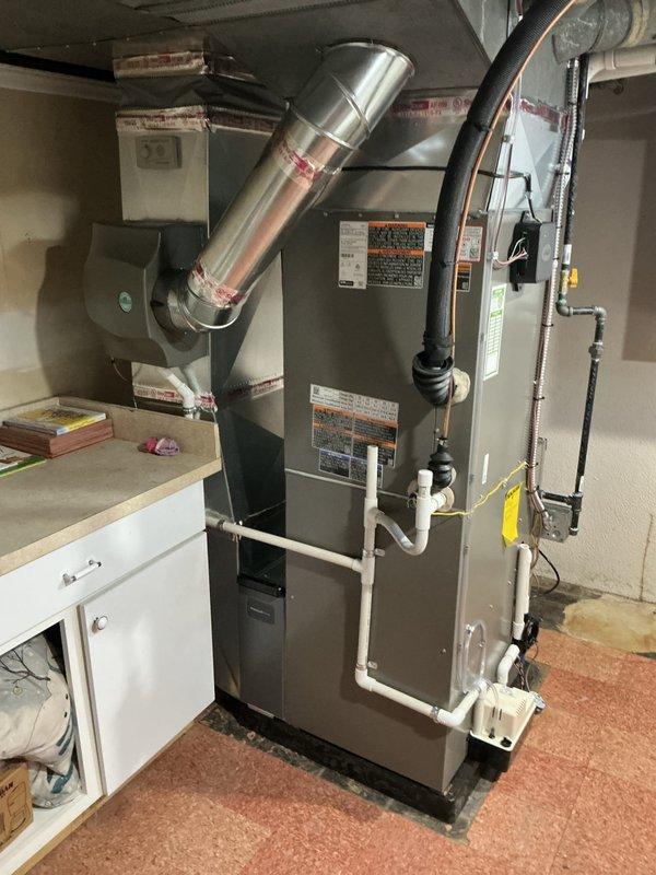 Completed full HVAC system installation including 90,000 BTU furnace and 3-ton air conditioning unit with left-side configuration. Installed humidifier, established all necessary PVC condensate drainage lines, reconnected gas supply lines, and routed metallic ductwork and electrical connections. Obtained mechanical and electrical permits prior to installation, with all work performed to code in basement utility area.